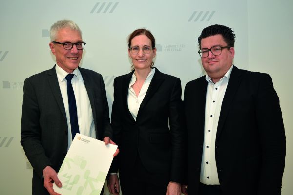 Der Kanzler der Universität Bielefeld Dr. Stephan Becker (l.) übergibt Univ.-Prof. Dr. Claudia Scherl (Mitte) ihre Ernennungsurkunde im Beisein von Bernd Henkemeier, kaufmännischer Direktor des Klinikum Bielefeld (r.).