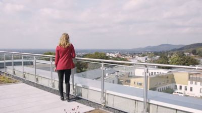 Video Teaser Bild Person guckt von Dachterrasse in die Ferne