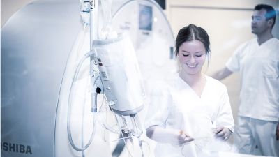 Bild medizinische Technologin für Radiologie mit Kollegen am Röntgengerät Bild medizinische Technologin für Radiologie mit Kollegen am Röntgengerät