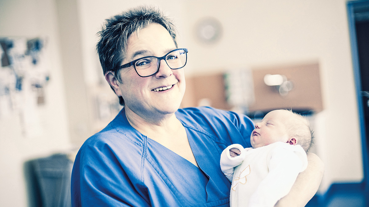 Bild von Krankenschwester hält Neugeborenes im Arm